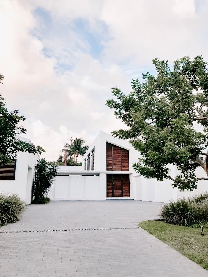 Crafting Captivating Headlines: Your awesome post title goes here Contemporary minimalist home exterior with lush landscaping and open driveway.